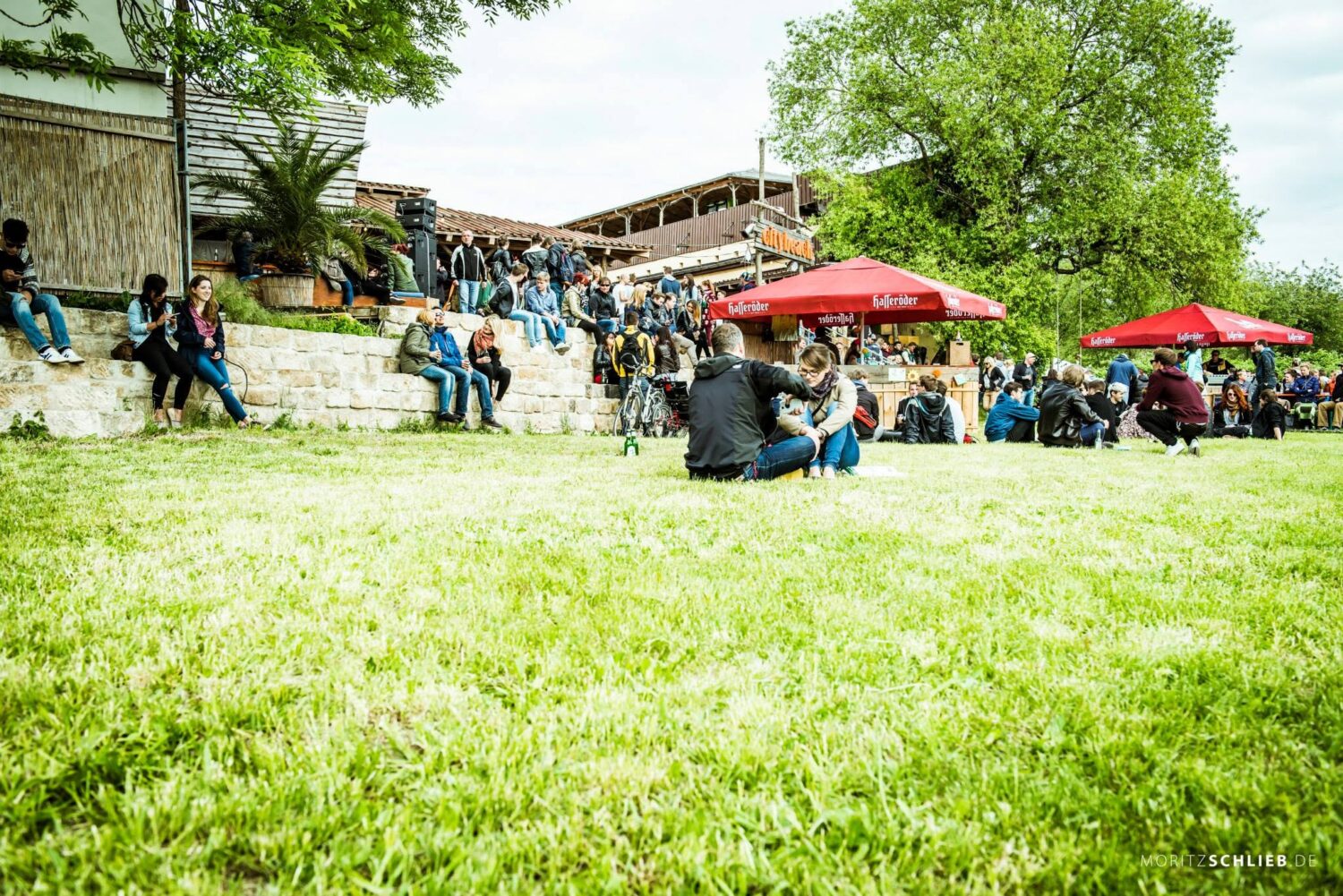 Entspannte Gäste auf grünen Wiese bei der sommerlichen Outdoor-Veranstaltung Schreber31 im Jahr 2015.