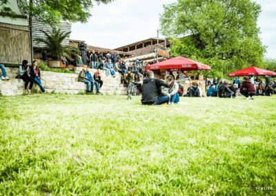 Entspannte Gäste auf grünen Wiese bei der sommerlichen Outdoor-Veranstaltung Schreber31 im Jahr 2015.