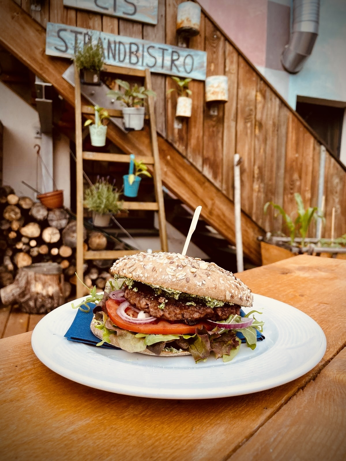 Saftiger, selbstgemachter Plant Smash Burger im Rustikobrötchen mit Cheddar und frischen Zutaten im Strandbistro vom Citybeach Dresden.
