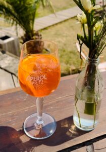 Ein erfrischender Aperol Spritz im Glas mit Eiswürfeln und Orangen scheibe aus unserer Karte für Speisen & Getränke.